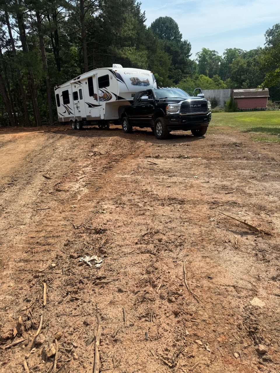Ram dually hooked to a Copper Canyon fifth wheel camper on a cleared lot
